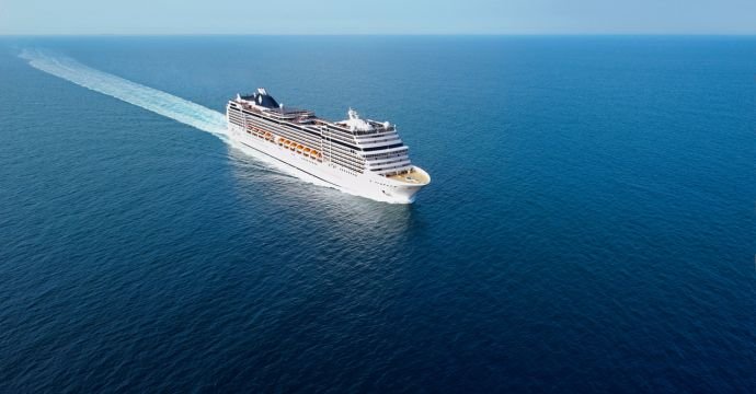 A modern cruise ship navigating through calm blue waters | MSC Cruises