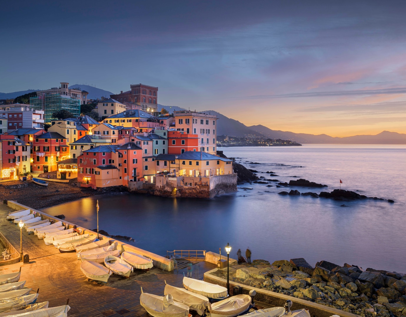 Colorful buildings lining a serene harbor at sunset | MSC Cruises