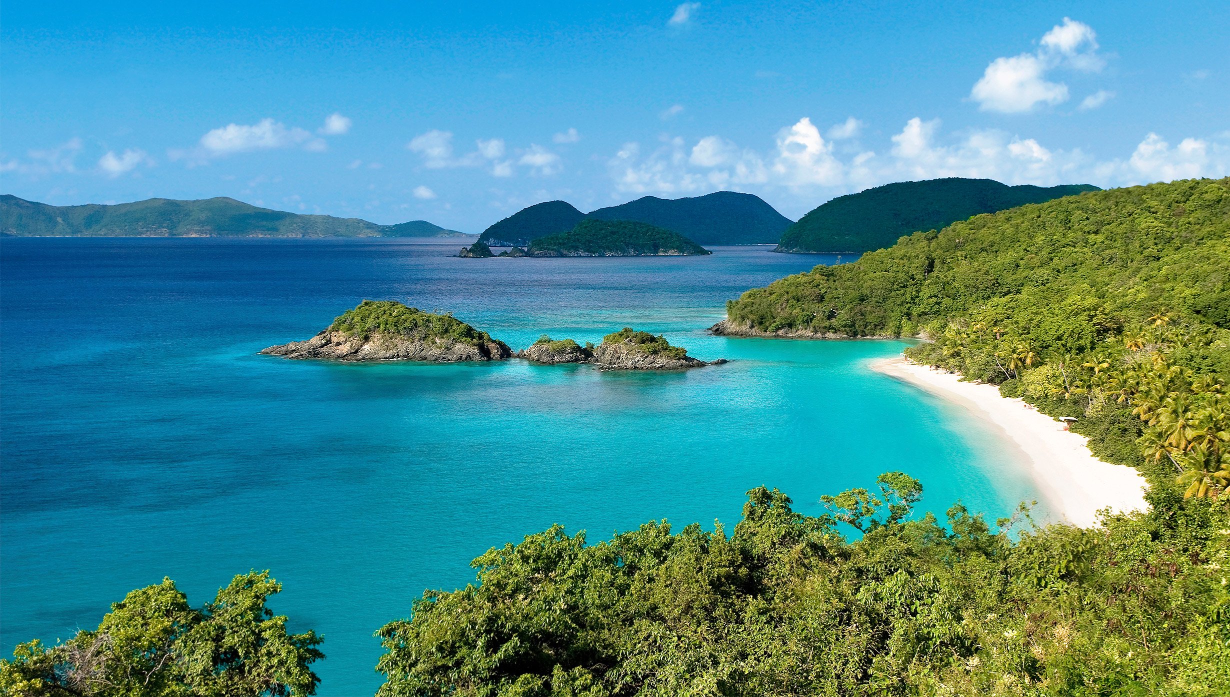 A secluded tropical beach with turquoise waters and lush green hills | MSC Cruises