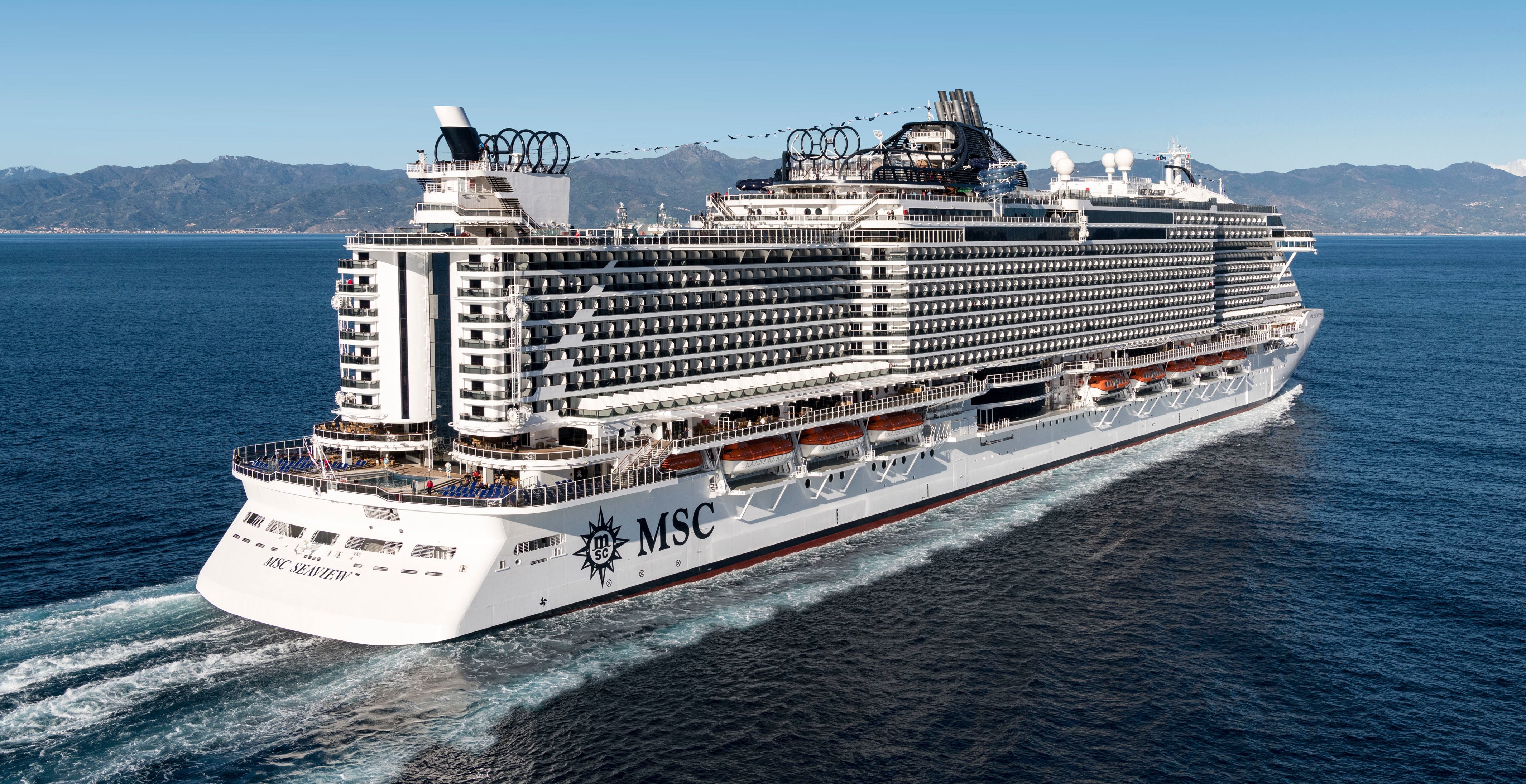 The MSC Seaview cruise ship sailing on open waters with mountains in the background | MSC Cruises