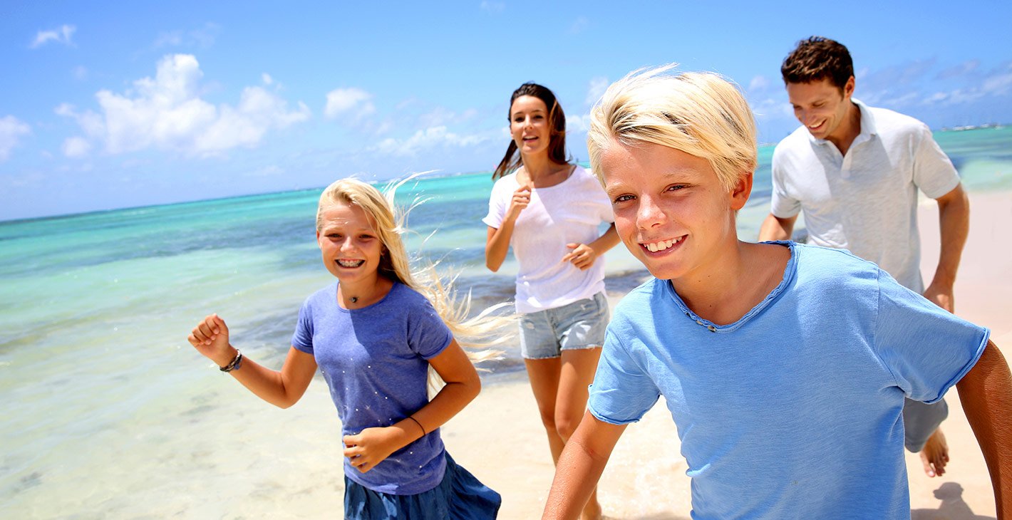 A family enjoying a sunny beach with turquoise water | MSC Cruises