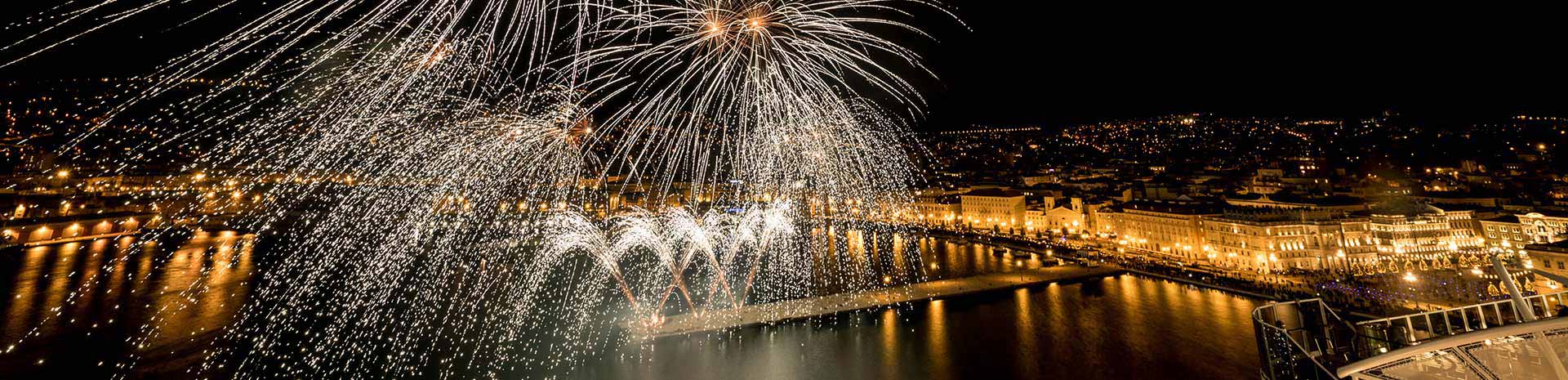 Fireworks illuminating a city waterfront at night, viewed from an MSC cruise ship | MSC Cruises Fireworks illuminating a city waterfront at night, viewed from an MSC cruise ship | MSC Cruises